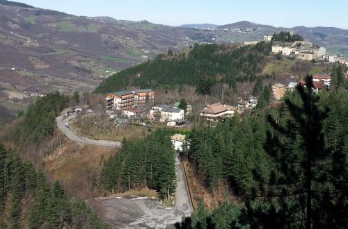 una ciudad en la cima de una colina con árboles en Residence Giardino, en Montecreto