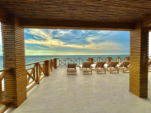 a deck with chairs and a view of the ocean at Apartamento - suite, Frente al mar in San Silvestre