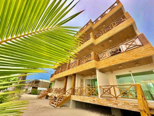un edificio con una palmera delante de él en Apartamento - suite, Frente al mar en San Silvestre