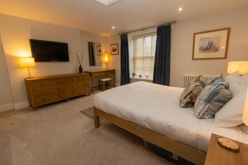 Schlafzimmer mit einem Bett und einem Flachbild-TV in der Unterkunft Oulton House - Beautiful Restored 2 Bedroom Property in Spofforth in Spofforth