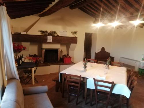a dining room with a white table and chairs at Antica Grancia Di Quercecchio in Montalcino
