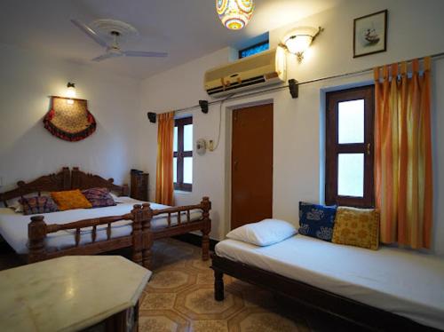 a living room with two beds and a table at Yogis Guest House in Jodhpur