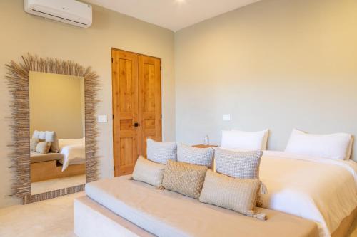 a bedroom with a large bed and a mirror at Cerritos Surf Town - Beach Front Property in El Pescadero