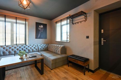 a living room with a couch and a table at Aparthotel Mamma Mia - Oświęcim in Oświęcim