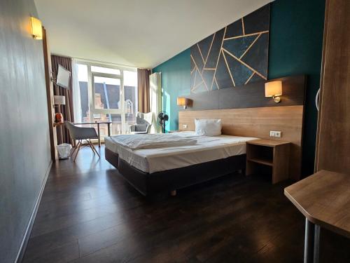 Hotel Luise Mannheim - by SuperFly Hotels في مانهايم: غرفة نوم بسرير وطاولة وكرسي