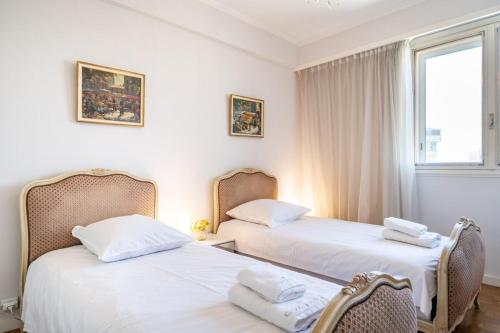 deux lits dans une chambre aux murs blancs dans l'établissement Charming 1 bedroom on the top floor, à Cannes