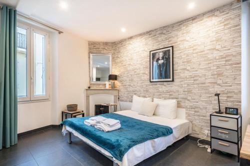 een slaapkamer met een bed en een bakstenen muur bij Nice studio in the heart of Cannes in Cannes