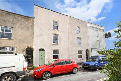 a red car and a blue car parked in front of a building at Stylishly refurbished townhouse in Bristol