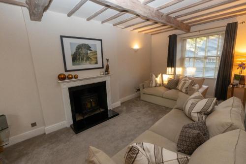 ein Wohnzimmer mit 2 Sofas und einem Kamin in der Unterkunft Oulton House - Beautiful Restored 2 Bedroom Property in Spofforth in Spofforth