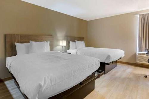 a hotel room with two beds and a window at Suburban Studios Raleigh - Crabtree Valley in Raleigh