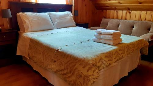 een slaapkamer met een bed met handdoeken erop bij Casa Tregül B&B in Villarrica