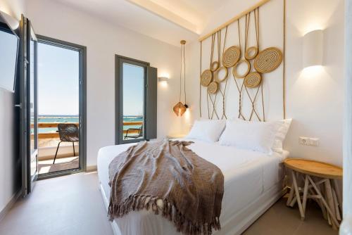 a bedroom with a bed with a view of the ocean at KIANO SUITES in Kampos Paros