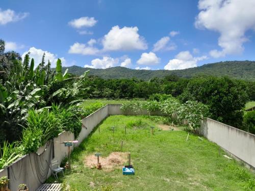 uitzicht op een tuin met bomen en bergen op de achtergrond bij Residencial Mãe terra in Bombinhas