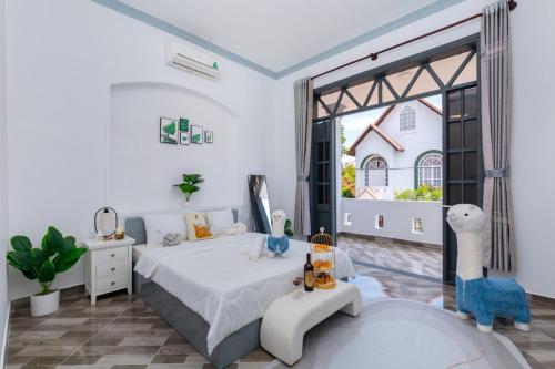 a white bedroom with a bed and a large window at Villa Hồ Bơi Vũng Tàu Gần Biển Free Bida + Karaoke - 28/2 LLQ in Vung Tau