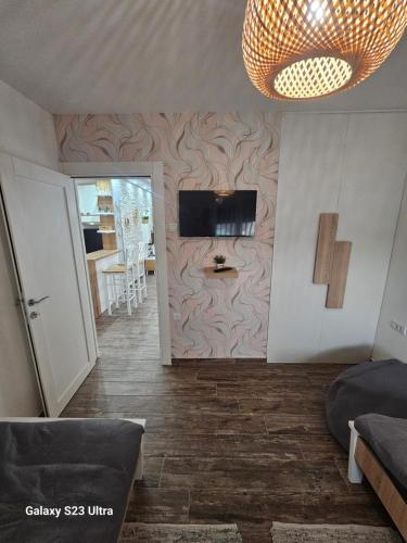 a living room with a tv on a wall at Apartman Una in Zrenjanin