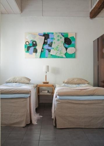 Alapiha Apartments في تامساري: غرفة نوم بسريرين ولوحة على الحائط