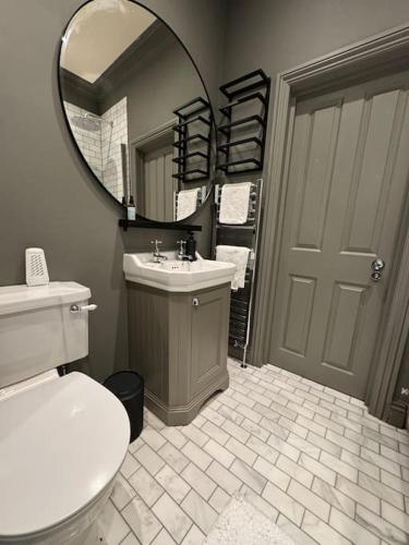 a bathroom with a toilet and a sink and a mirror at Luxury Apartment, Old Town - Hastings in Hastings
