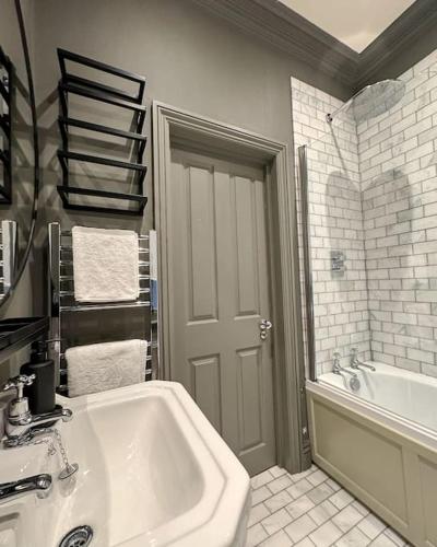 a bathroom with a white tub and a sink at Luxury Apartment, Old Town - Hastings in Hastings