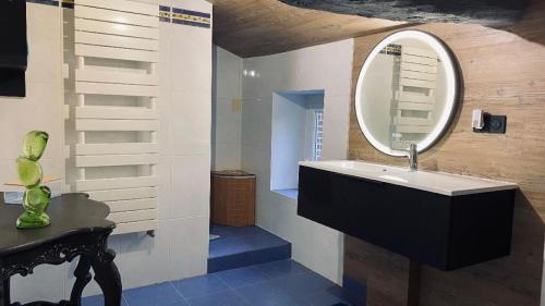 uma casa de banho com um lavatório e um espelho em Au bon endroit em Sevremont