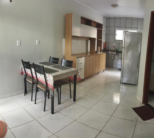 eine Küche mit einem Tisch und Stühlen sowie einem Kühlschrank in der Unterkunft Apartamento Central Privativo in Boa Vista