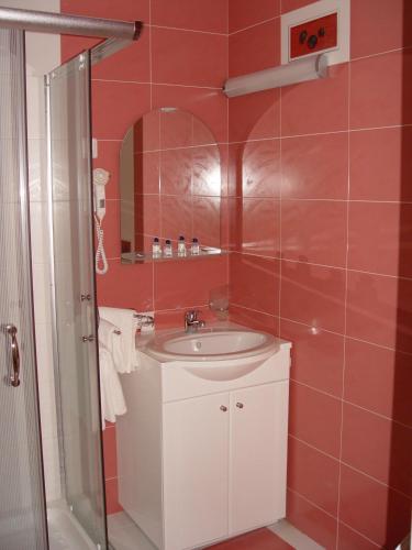 a bathroom with a white sink and a shower at Family Hotel Gabrovo in Gabrovo