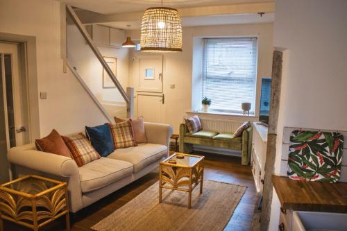 a living room with a couch and a table at Spa Garden Cottage - Upper Hopton in Mirfield