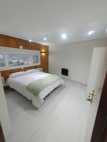 a white bedroom with a large bed and a window at Torre de laredo 9-3 in Laredo
