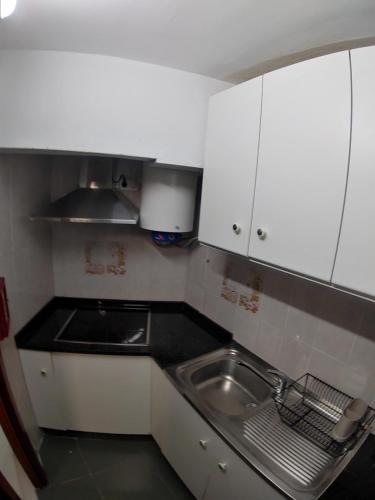 a small kitchen with a sink and white cabinets at Torre de laredo 9-3 in Laredo