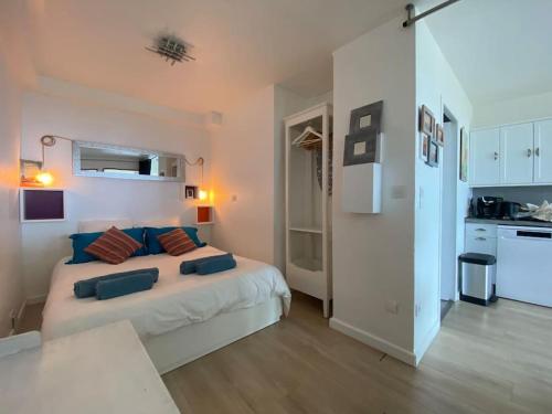 um quarto com uma cama com almofadas azuis em Appartement vue mer mont des oiseaux em Hyères