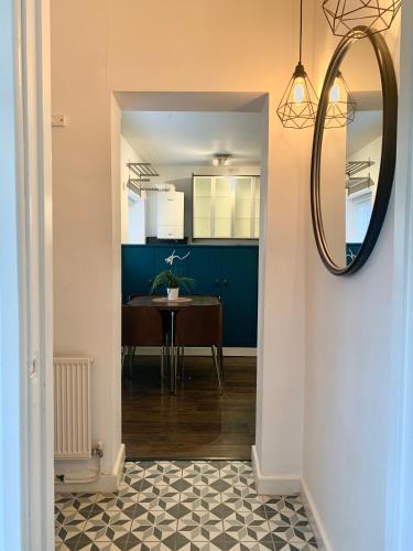 a hallway with a dining room and a mirror at DIDSBURY Fáilte Inn Apts - 3 Mins to The Christie's - Ground Floor - FREE Parking in Manchester
