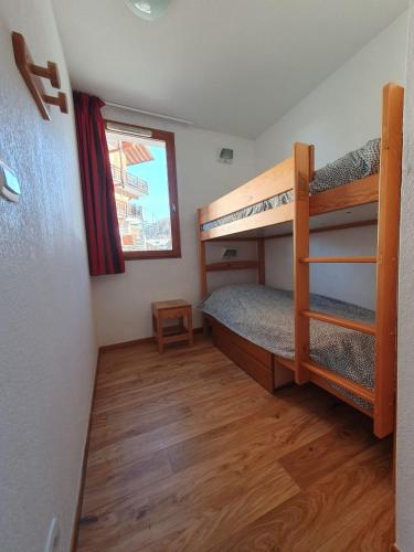 une chambre avec deux lits superposés et une fenêtre dans l'établissement Montagne Les Orres, aux Orres