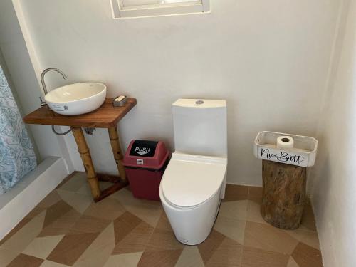 a bathroom with a white toilet and a sink at Tabskie’s Homestay in Catarman