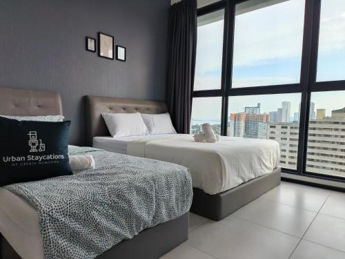 a hotel room with two beds and a large window at New Urban Suite Majestics 3BR Homestay at Georgetown BY URBAN STAYCATION HENG LOD in Jelutong