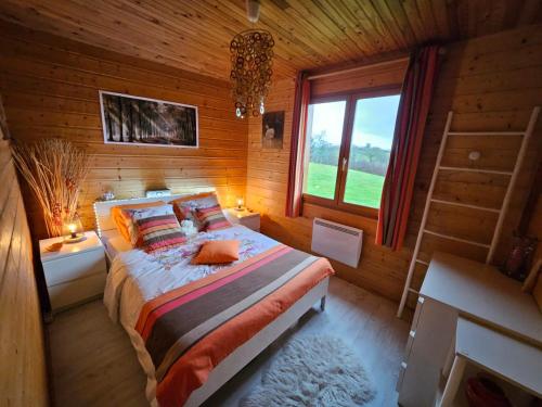 1 dormitorio con 1 cama en una cabaña de madera en Grand Chalet, en Bourbon-Lancy
