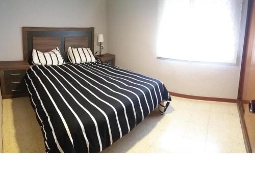 セグル・デ・カラフェルにあるBabsi's Apartmentのベッドルーム1室(白黒のベッド1台、枕2つ付)