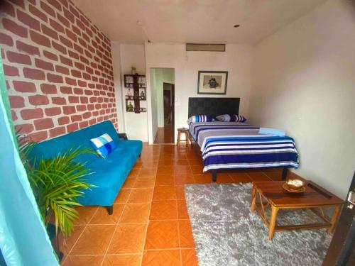 a living room with two beds and a brick wall at Suite céntrico vista al Mar in Montañita