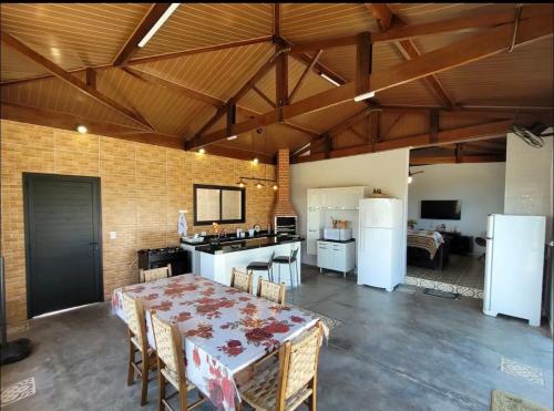 a kitchen and dining room with a table and refrigerator at Recanto NS Aparecida in Socorro