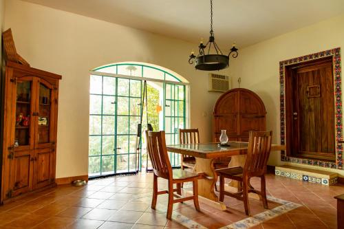 a dining room with a wooden table and chairs at Bombon Guesthouse in Brisas de Zicatela