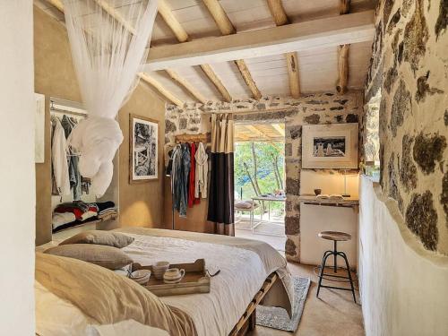 a bedroom with a large bed and a stone wall at Casa nel Bosco, un oasi di pace in Seccheto