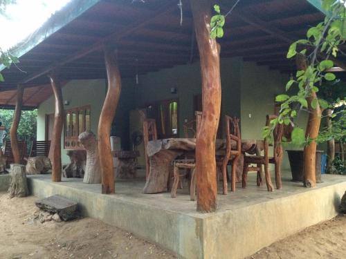 Habitación con mesa, sillas y árboles en Thimbiriwewa Eco Resort Wilpattu, en Nochchiyagama