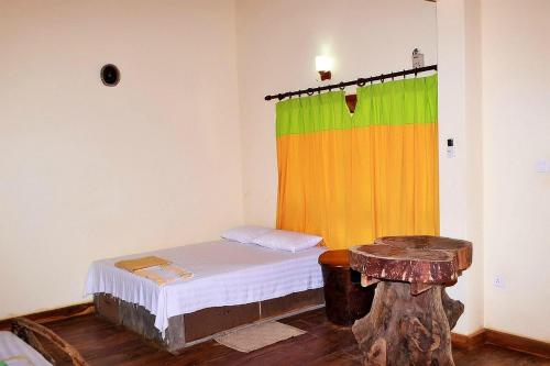Habitación con cama con cortina colorida en Thimbiriwewa Eco Resort Wilpattu, en Nochchiyagama