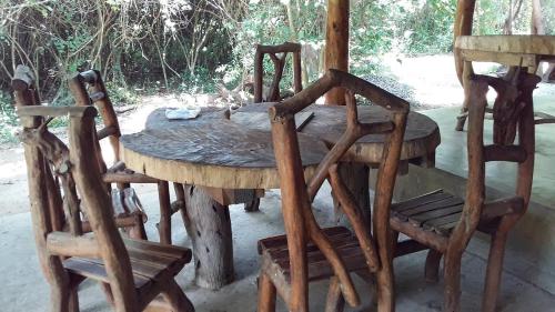 mesa de madera con 4 sillas y mesa de madera con madera en Thimbiriwewa Eco Resort Wilpattu, en Nochchiyagama