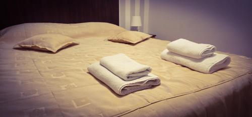 białe łóżko z ręcznikami na górze w obiekcie Pensiunea Roua w mieście Sinaia