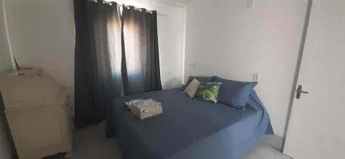 a bedroom with a bed with blue sheets and a window at Casa Celeste Búzios in Búzios