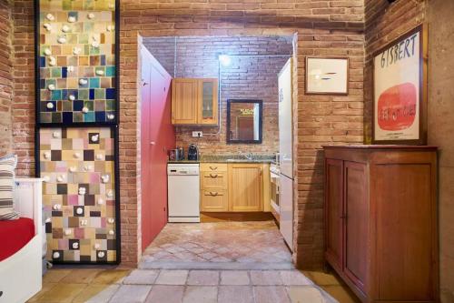 cocina con pared de ladrillo y puerta abierta en Loft Art Studio Sant Cugat - Barcelona en Sant Cugat del Vallès