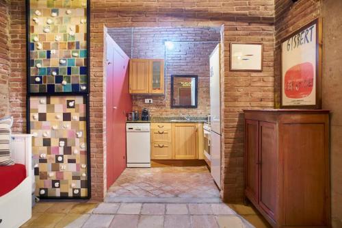 a kitchen with a brick wall and an open door at Loft Art Studio Sant Cugat - Barcelona in Sant Cugat del Vallès