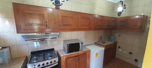 a kitchen with wooden cabinets and a stove and refrigerator at San Ignacio zona 7 in Mixco