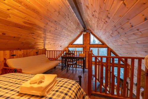 een kamer met een bed en een tafel in een hut bij Royal St-Côme Private Hot Tub Chalet Retreat in Saint Come