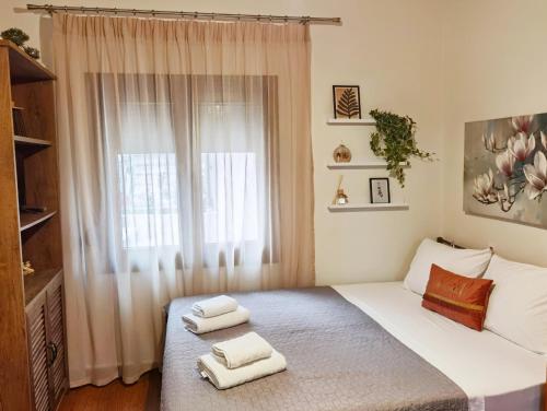 una camera da letto con un letto e due asciugamani di Sailor's Delight a Kavala