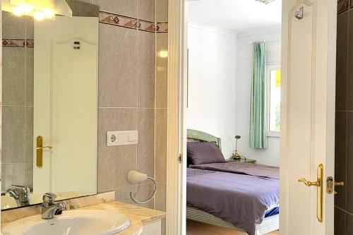 een badkamer met een wastafel en een bed in een kamer bij Villa Flor de Neu in Denia